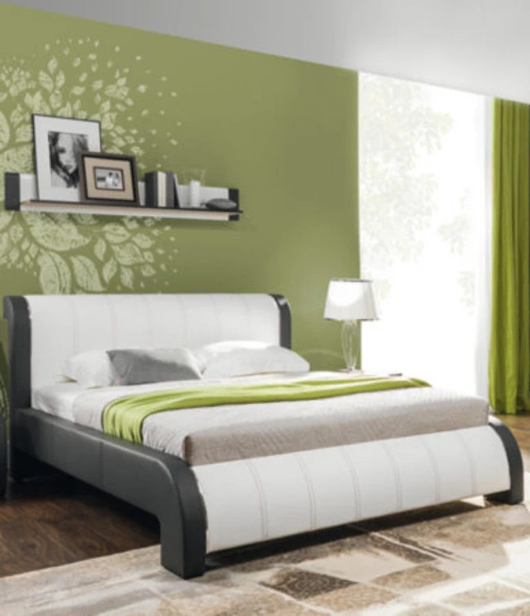 Łóżko i zielona ściana